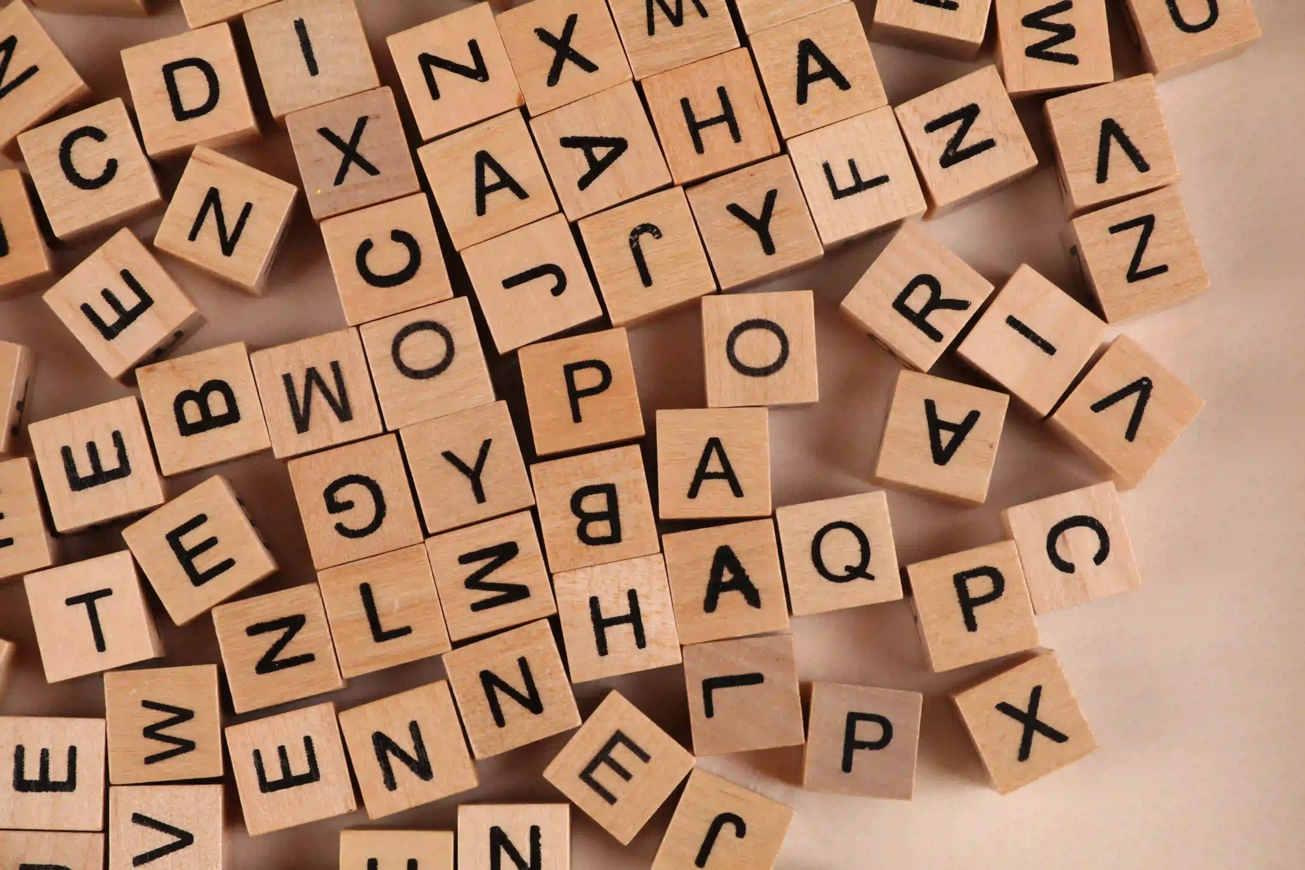 Lettres en bois disposées en désordre représentant l’alphabet.