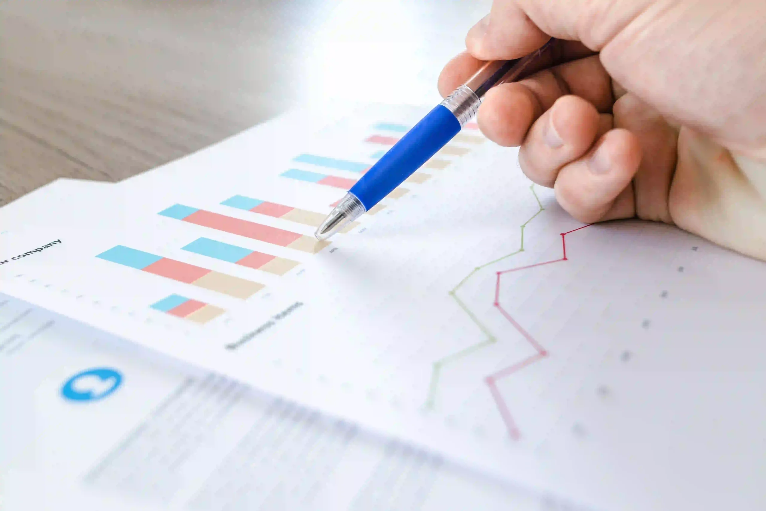 ne personne analyse des graphiques et des données chiffrées à l’aide d’un stylo.