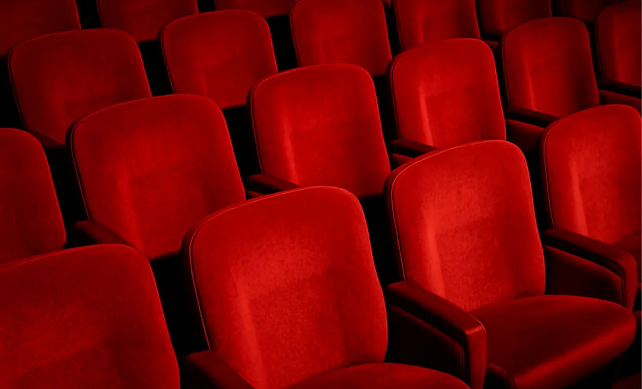 Rangées de fauteuils rouges dans une salle de cinéma