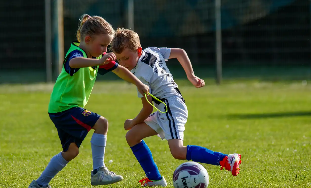 Deux enfants jouant au football sur un terrain