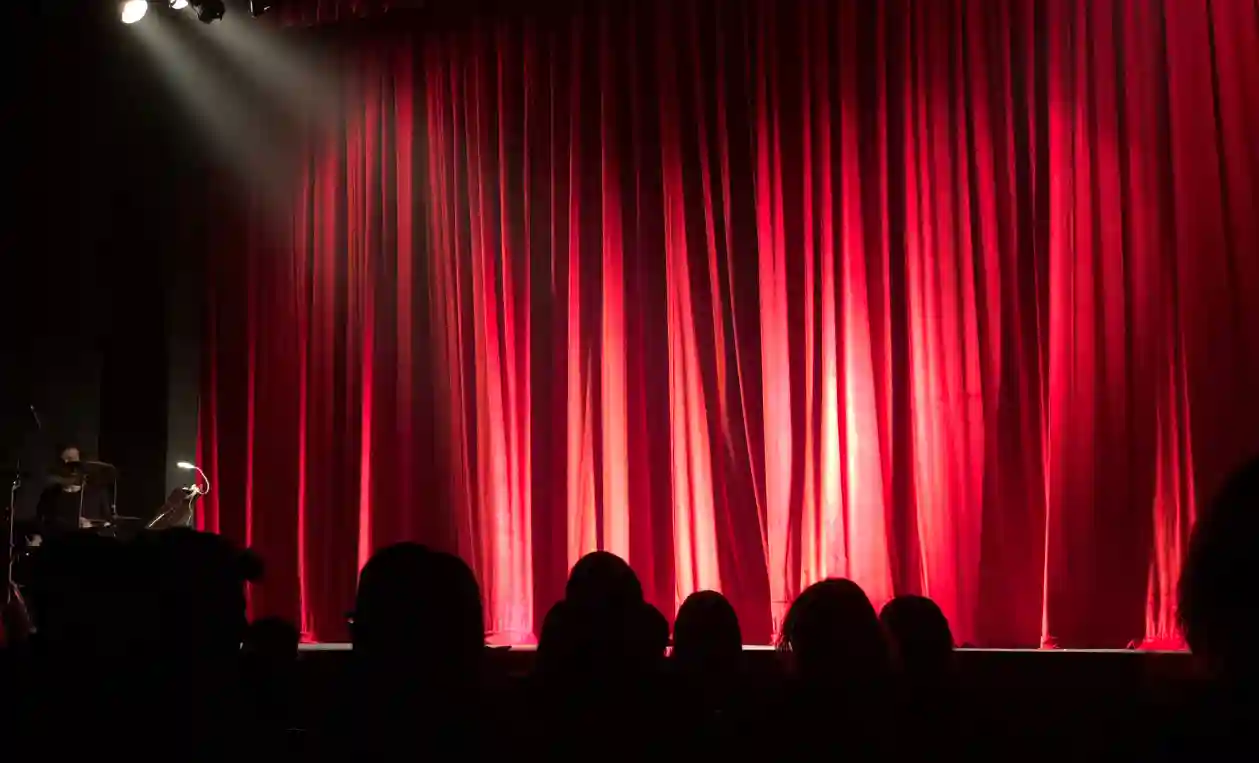 Rideau rouge d’une scène de théâtre devant le public
